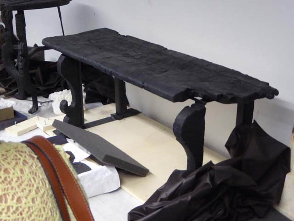 Decumanus Maximus, Herculaneum. September 2016. Carbonised wooden bench/long seat with moulded front legs.
Photo courtesy of Michael Binns.
According to De Carolis, this bench was found in Decumanus Maximus.
See De Carolis, E. (2007). Il mobile a Pompei ed Ercolano, letti tavoli sedie e armadi. Rome, “L’ERMA” di Bretschneider, (p. 131, fig.95).